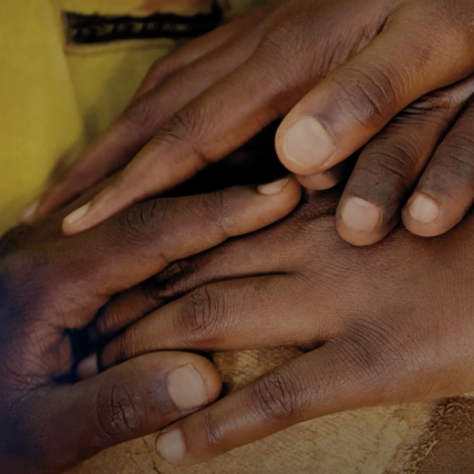 Close up picture of different hands holding each other.