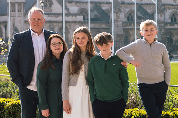 Gilfert family standing together outside in the sun.