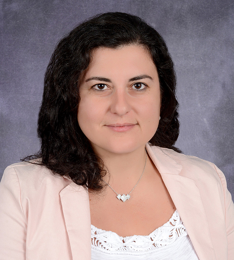 Woman in pink blazer smiling.