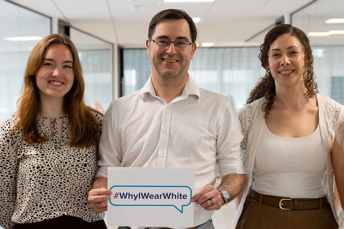 Hologic employees wearing white and holding signs at a company event raising awareness of uterine fibroids