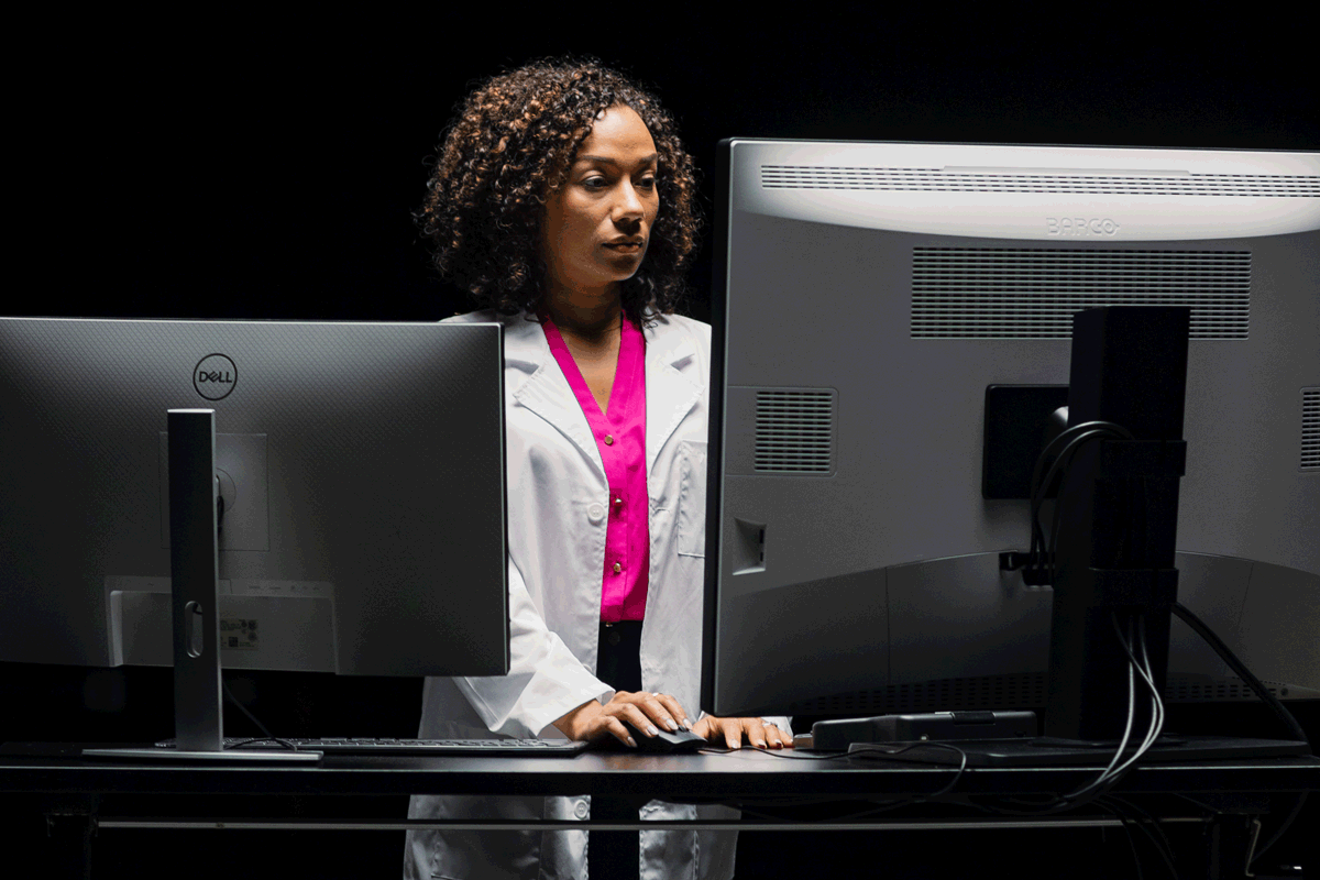 Doctor reviews mammogram images on a monitor.
