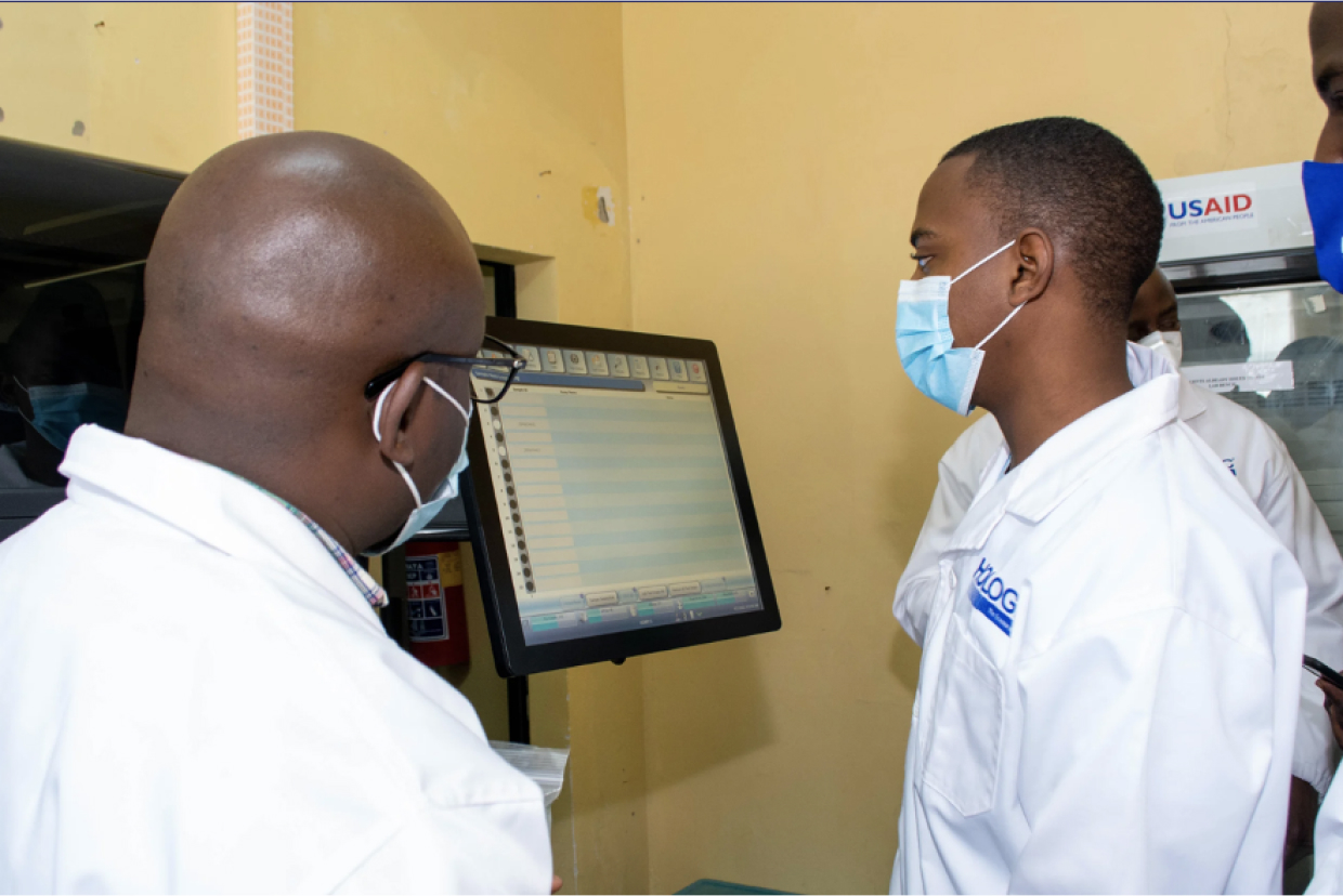 Lab technicians standing with Panther system in a lab setting.