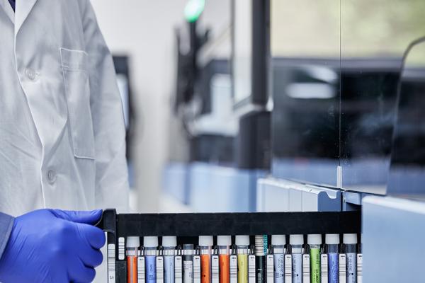 Closeup of lab technician loading Panther device with tests.