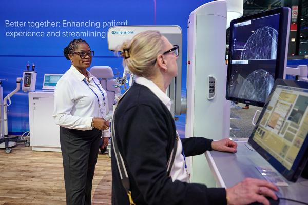 Two women reviewing x-ray images on a monitor display in a lab setting.