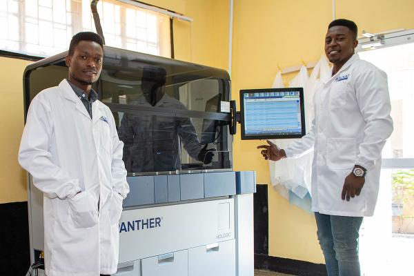 Two technicians working with medical equipment in lab setting.