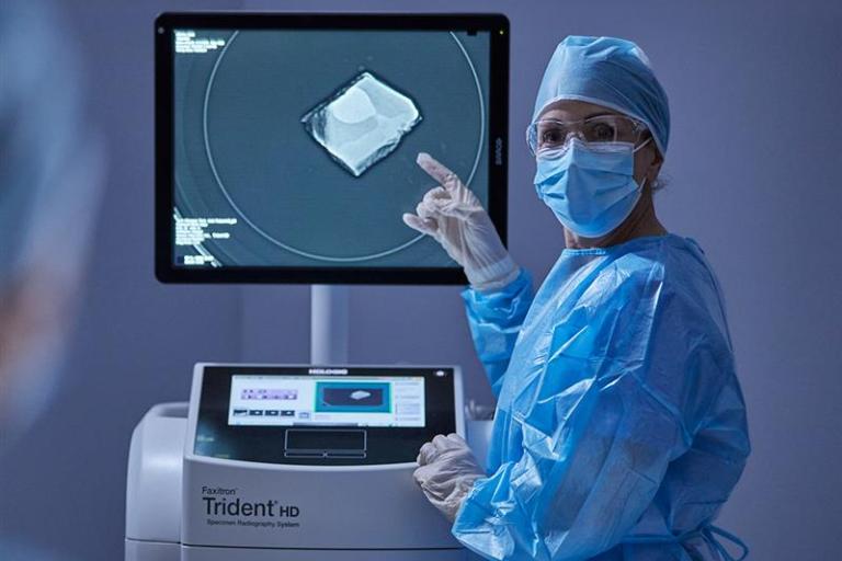 Healthcare professional pointing to screen on medical device