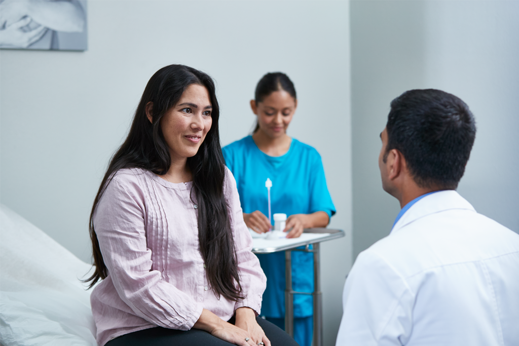 Patient speaking to physician in examination room.