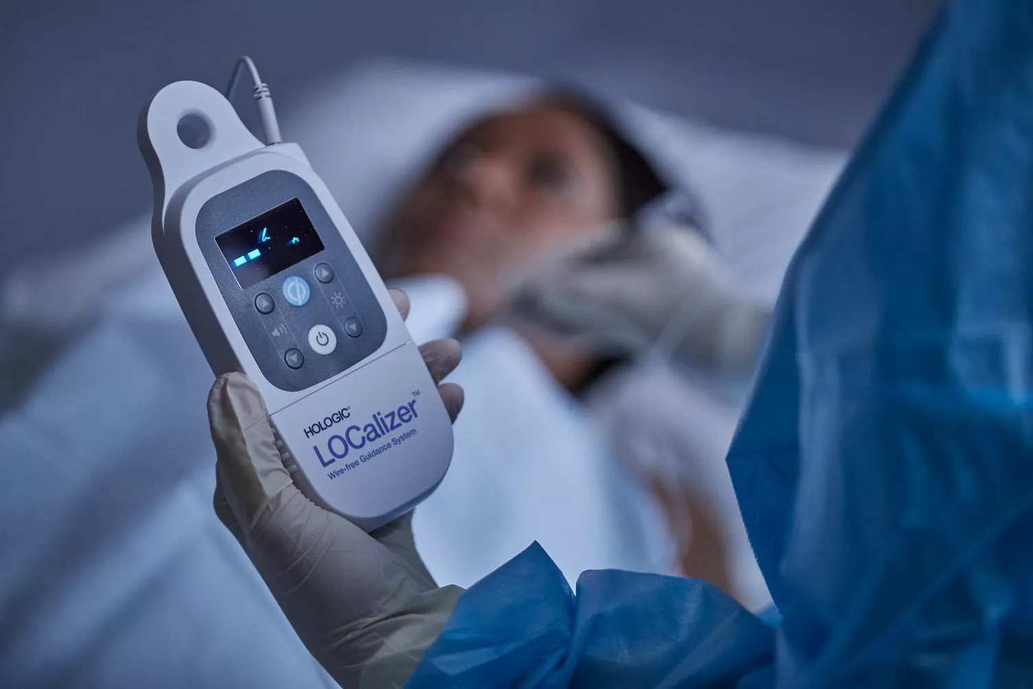 Woman lying down on breast imaging system with technician