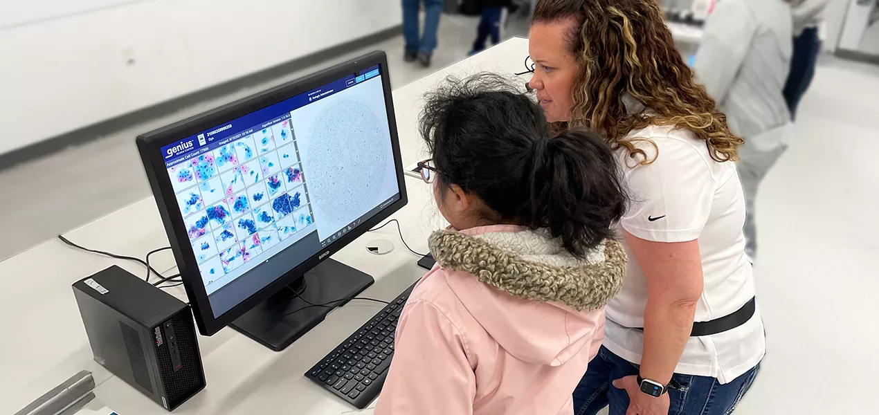Volunteer helping a student use the genius system