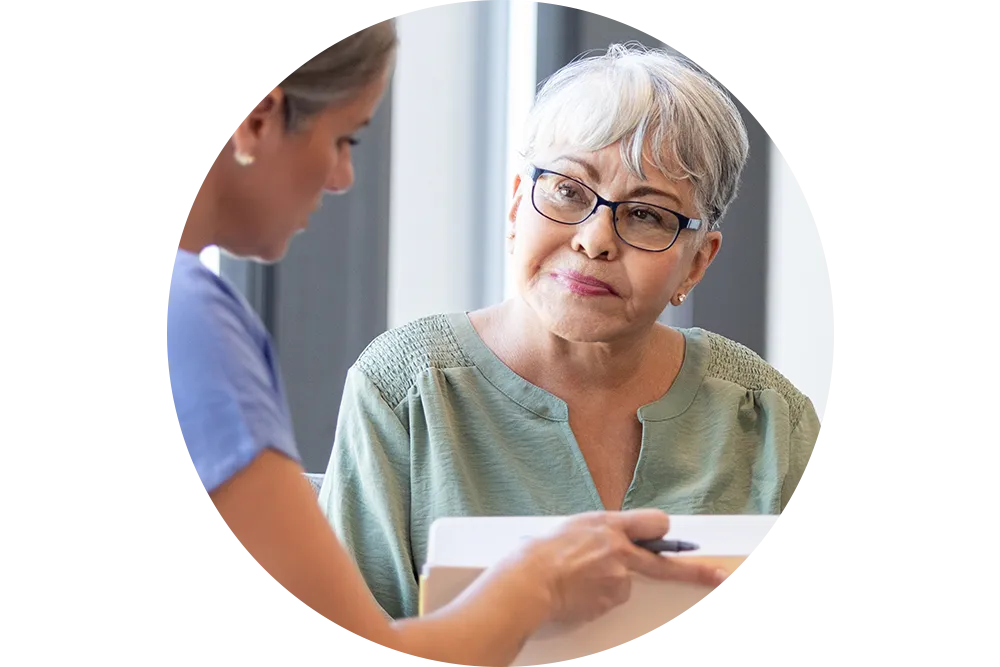 Healthcare provider sitting and talking with elderly patient