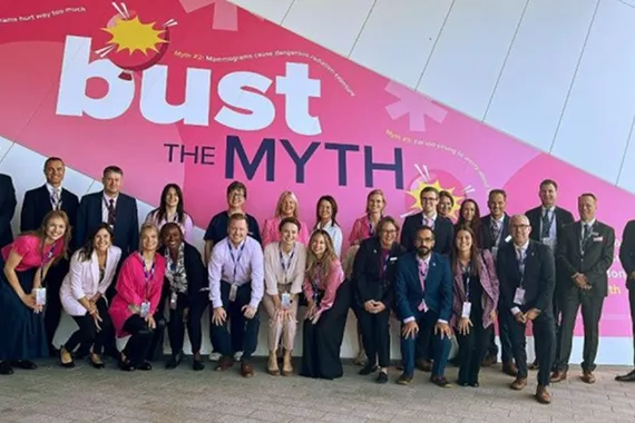 Group photo standing in front of large banner.