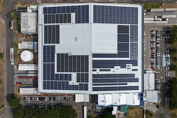 Aerial photo of building rooftop with solar panels.