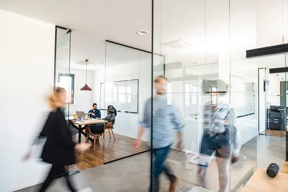 Photo of people walking through office hallway