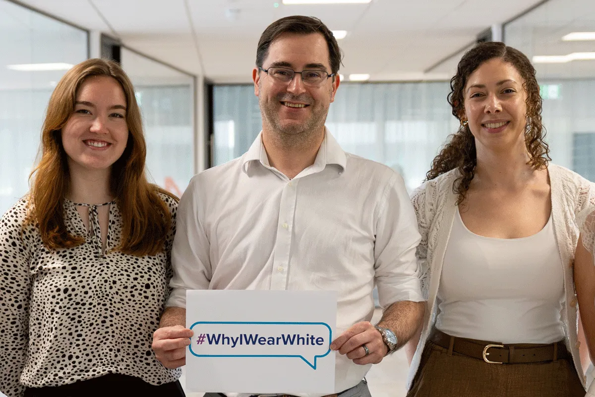 Hologic employees wearing white and holding signs at a company event raising awareness of uterine fibroids