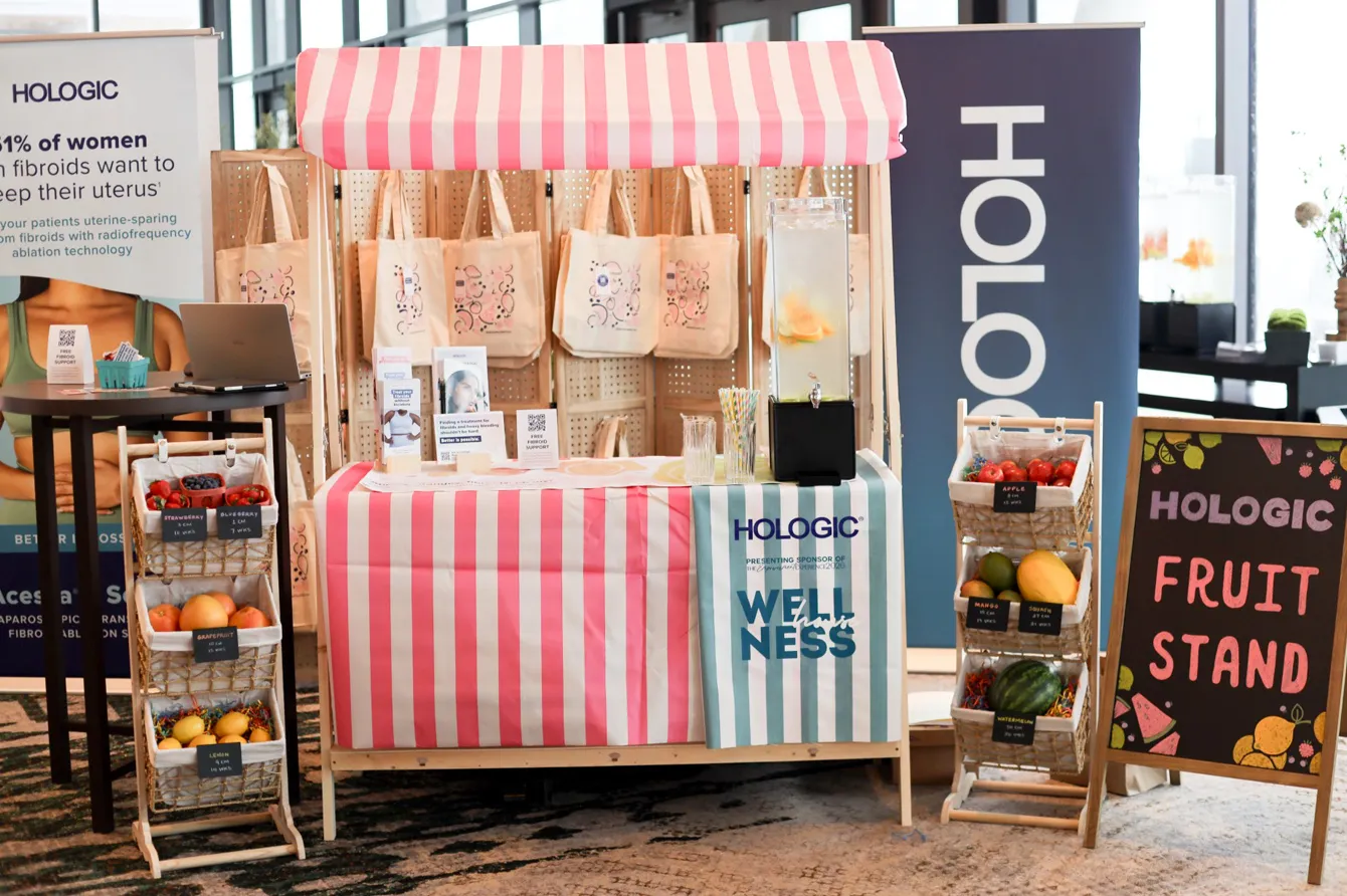Hologic fibroid fruit stand and Wellness House booth offering fibroid patient education materials at the Empowerment Experience
