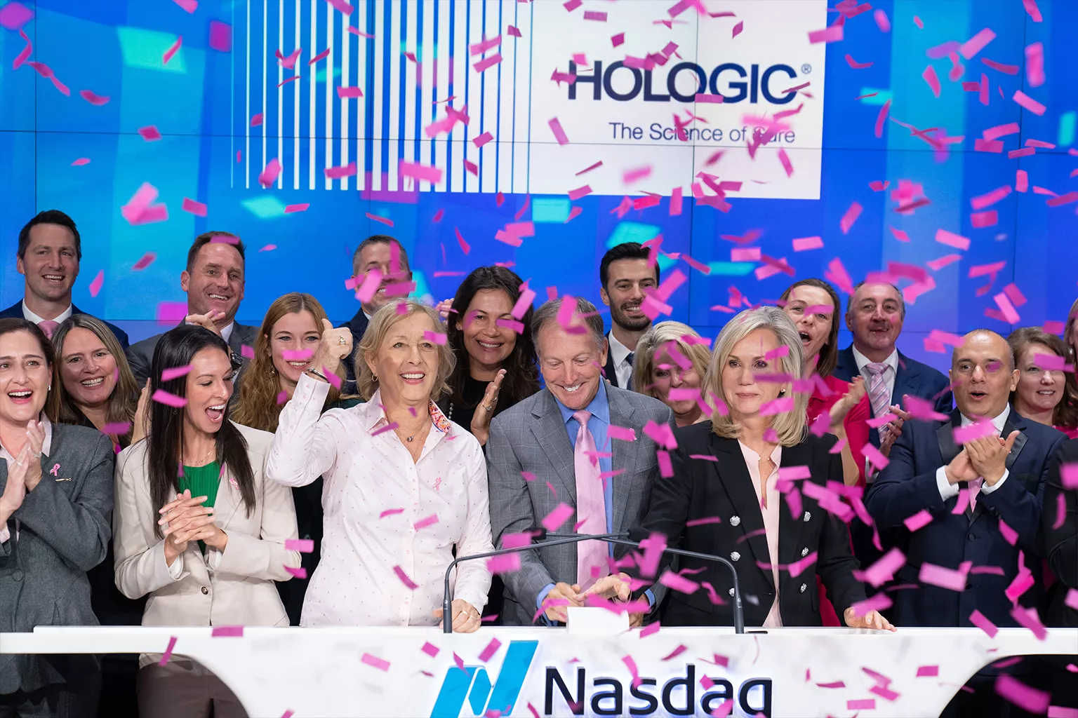 Group photo with CEO Steve MacMillan, WTA legend Martina Navratilova and WTA President Micky Lawler at a podium with falling confetti.