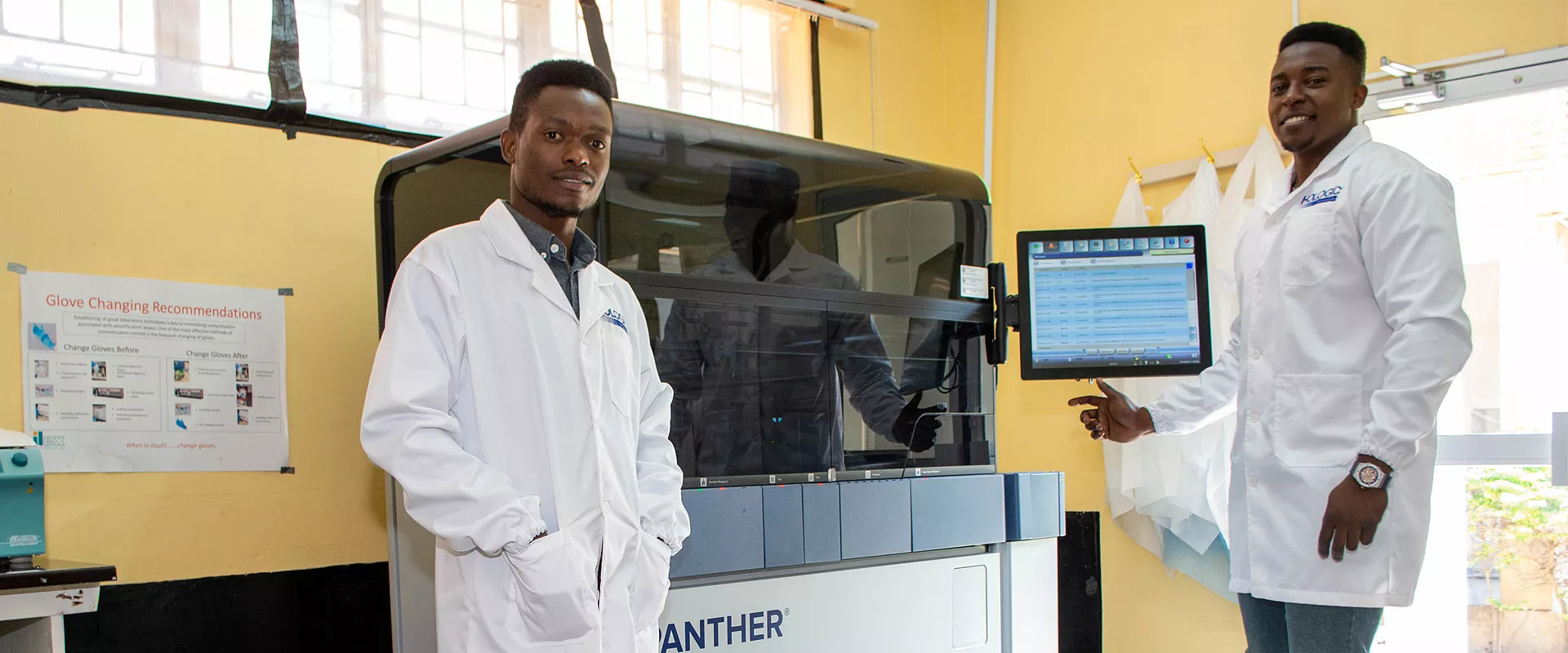 Two technicians working with medical equipment in a lab setting.