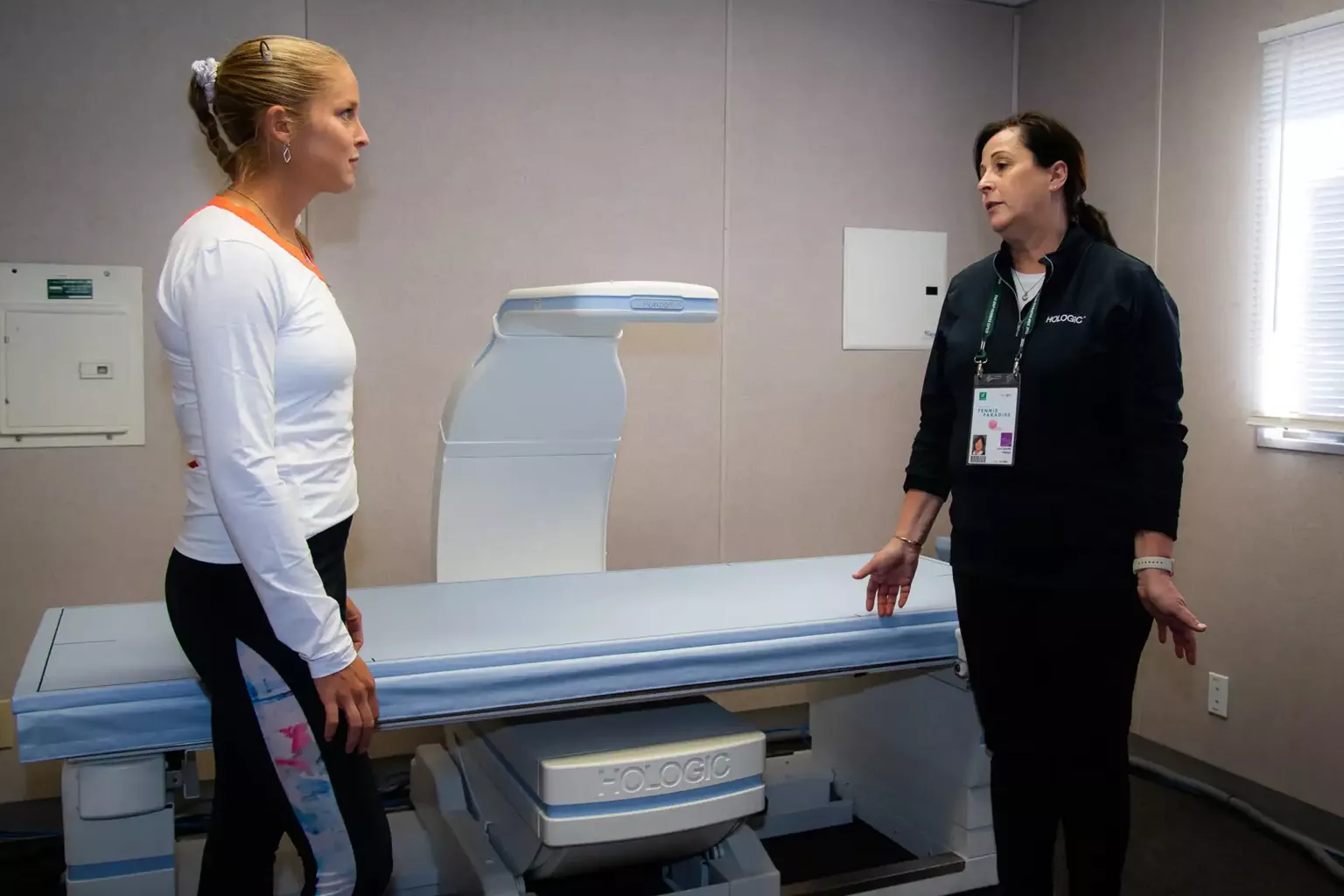 WTA tennis pro Shelby Rogers talks with Hologic’s Joan Spoden about the Horizon DXA body composition system in an exam room.